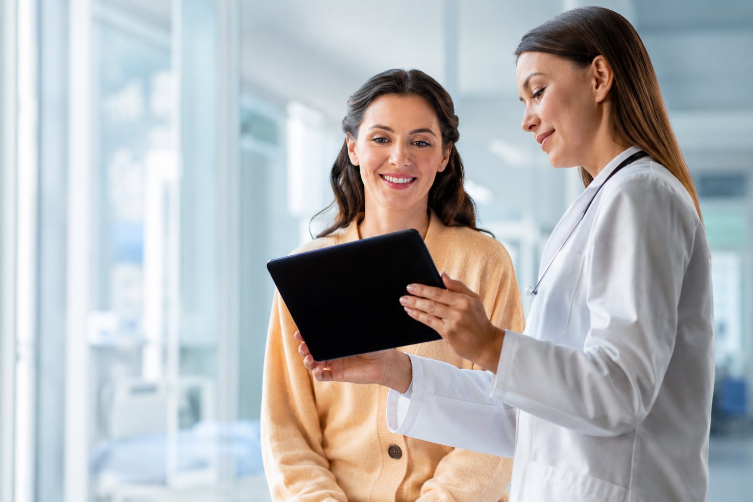 Personal médico y paciente de Hospitales MAC revisando información clínica juntos